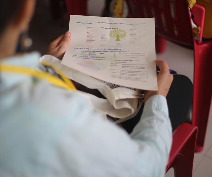 Hombre sentado sosteniendo una hoja en taller