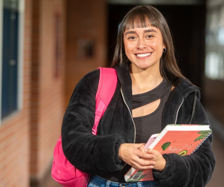 estudiante con cuadernos y maletín
