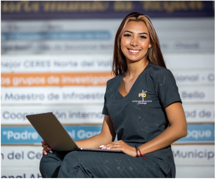 estudiante con uniforme de UNIMINUTO y un portátil