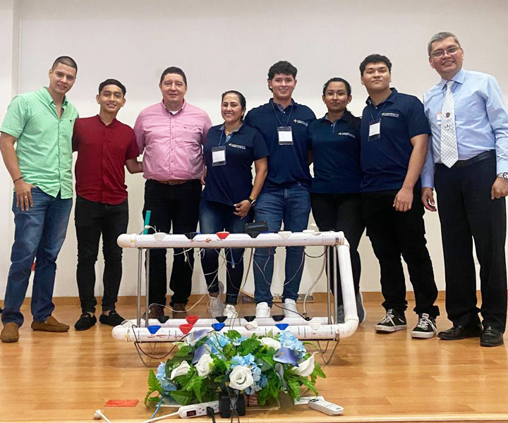 Grupo de docente y estudiantes de UNIMINUTO posando con su sistema hidropónico automatizado23