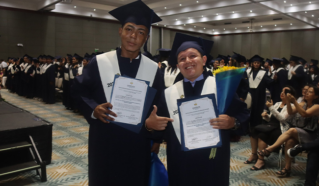 Dos graduados del Centro Universitario Villavicencio posan sonrientes con su diploma