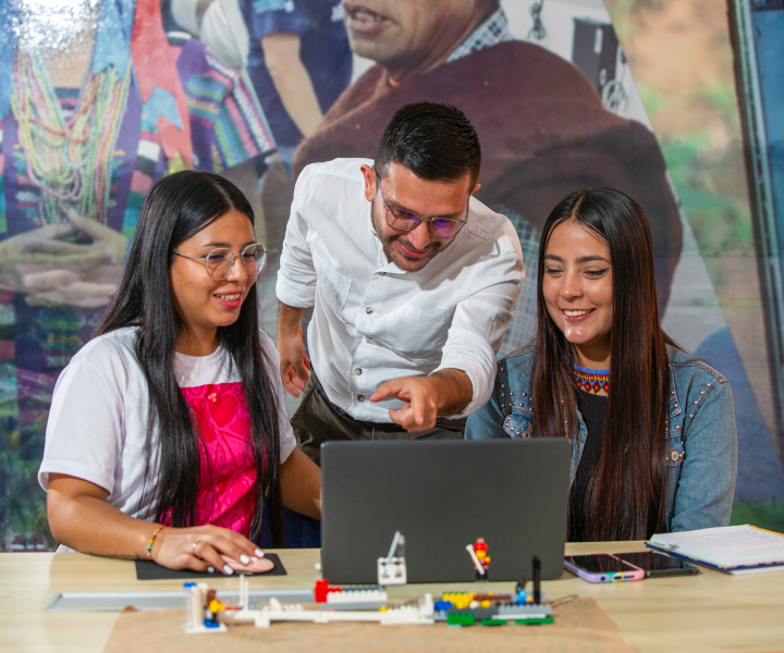 Estudiantes sonrientes viendo computador