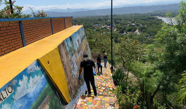 Voluntarios pintando mural comunitario.