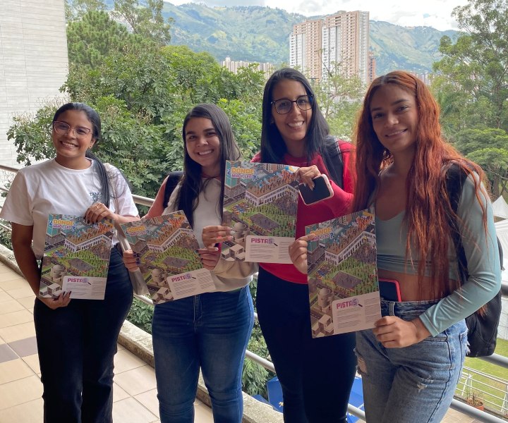 Estudiantes sonrientes mostrando mapa del concurso