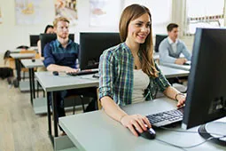 Personas escribiendo en una sala de computadores