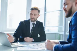 Hombres en mesa de trabajo revisando documentos