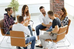Grupo de jóvenes reunidos en mesa redonda 