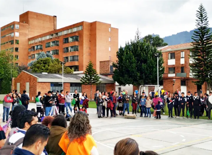 Un grupo de personas de diferentes étnias comparten de un encuentro en la cancha de fútbol del centro de operación San Camilo