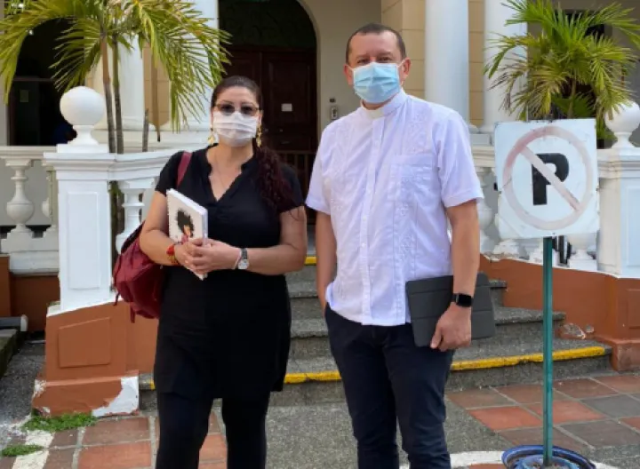 dos personas de píe, una mujer y un hombre con tapabocas