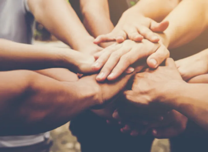 Grupo de personas enlazando sus manos en unión