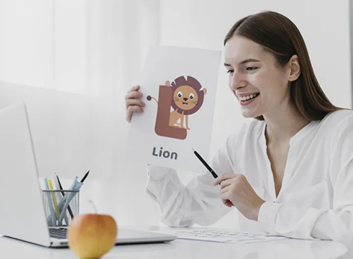 Una mujer blusa blanca sentada en un escritorio con una hoja en la mano y un computador