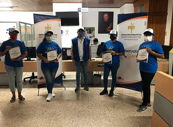 cuatro mujeres y un hombre alineados con tapaboca y chalecos azules