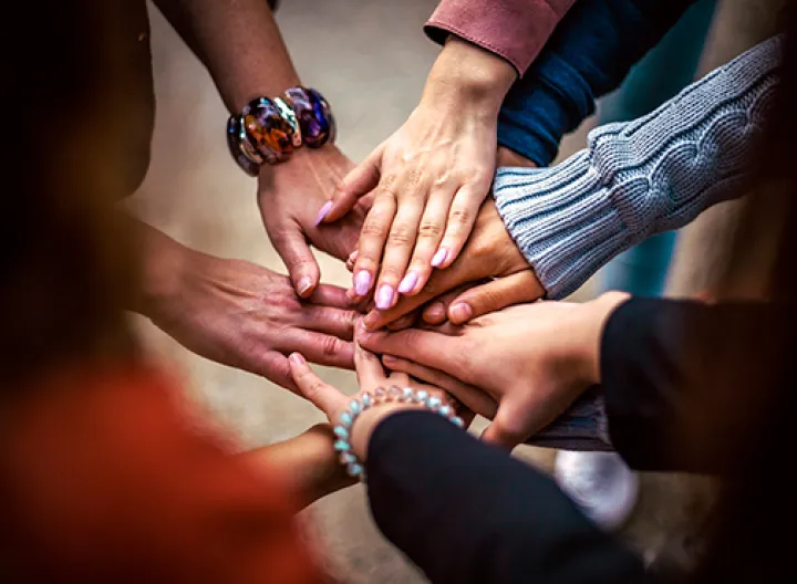 Personas con sus manos en símbolo de unión