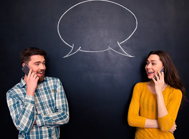Dos personas hablan por celular, sosteniendo una consersación entre esos. Una burbuja de diálogo entre ambos une la conversación.