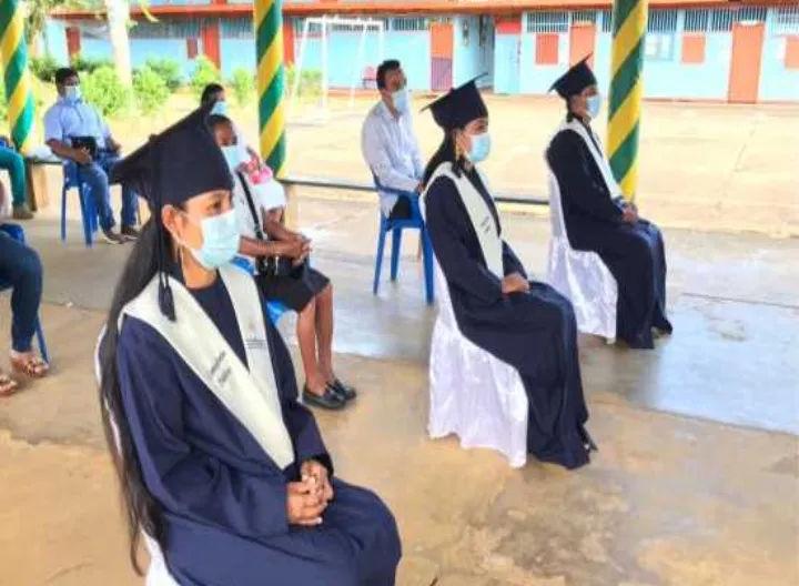 Dos personas sentadas con toga y birrete 