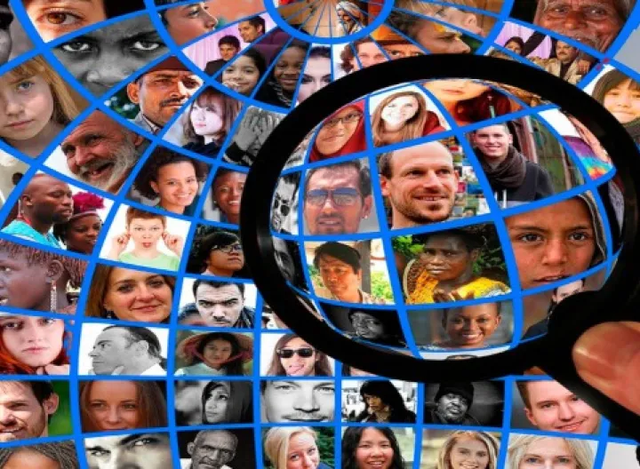 Caras de muchas personas y adelante una lupa