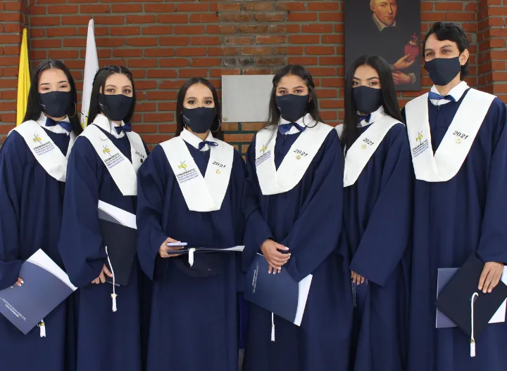 Seis estudiantes certificados con toga, ubicados en una fila. miran al frente.