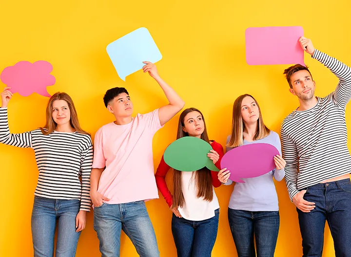 Cinco jóvenes en fondo amarillo, cada uno porta un globo de diálogo vacío, haciendo alución a pensamiento y conversación.
