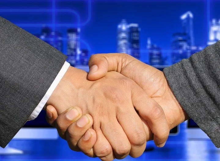 Dos personas dándose la mano como acto de alianza 