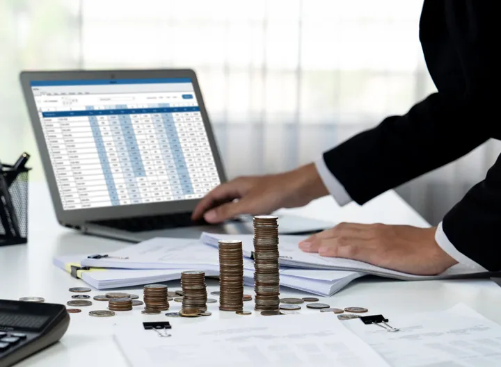 computador juanto a unas monedas en un escritorio