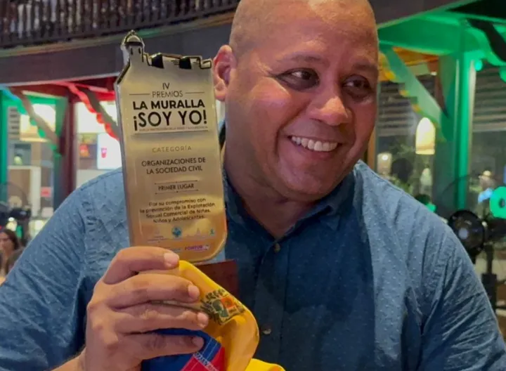 Docente con el reconocimiento en la mano 