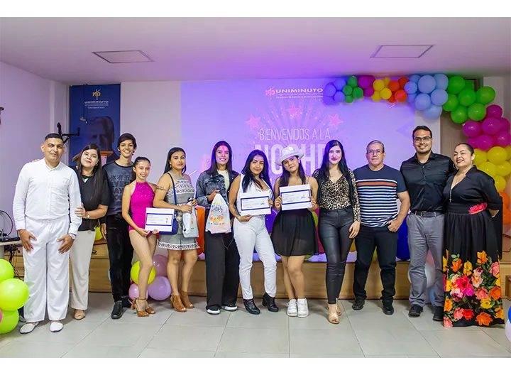 Imagen grupal de los participantes y jurado de la Noche de Talentos en el Centro Universitario Cúcuta, realizada durante la Semana UNIMINUTO 2024. Se observa a los estudiantes que participaron en las categorías de canto y baile, junto con los miembros del jurado. El evento estuvo decorado con globos de colores, creando un ambiente festivo y alegre.