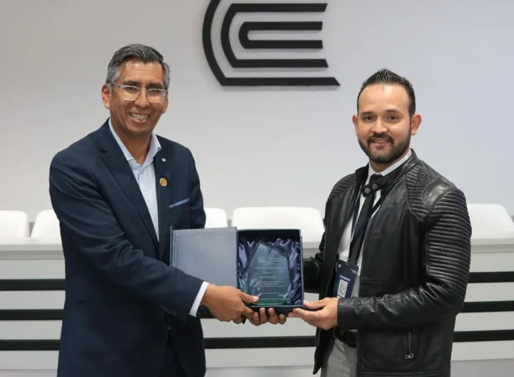 Decano de la Facultad de Ciencias Económicas y Administrativas UNIMINUTO recibiendo un reconocimiento.