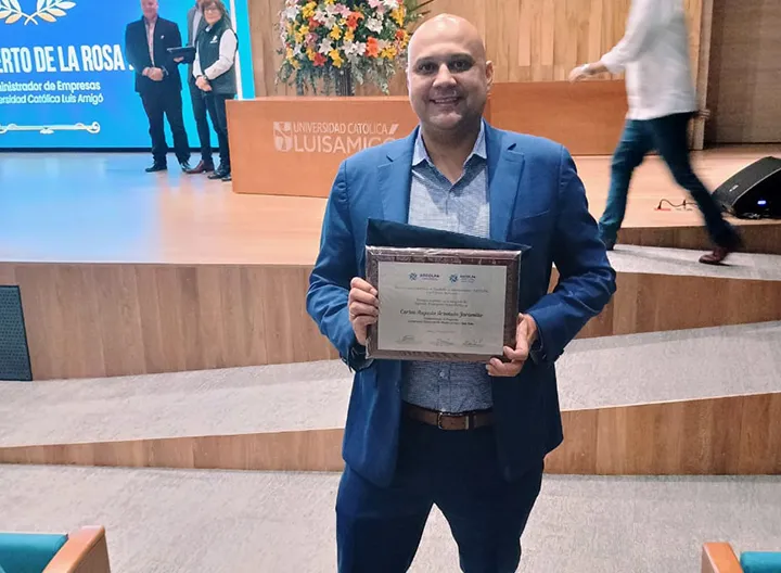 Egresado de UNIMINUTO recibiendo un reconocimiento de ASCOLFA. 