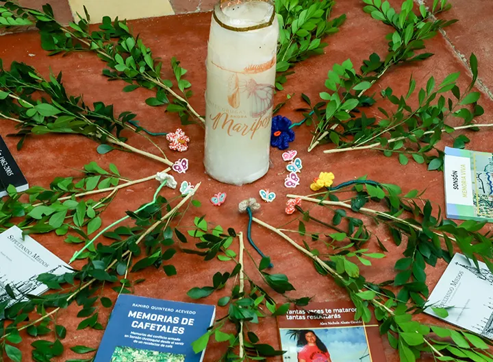 Ritual simbólico con vela, ramas y libros. 