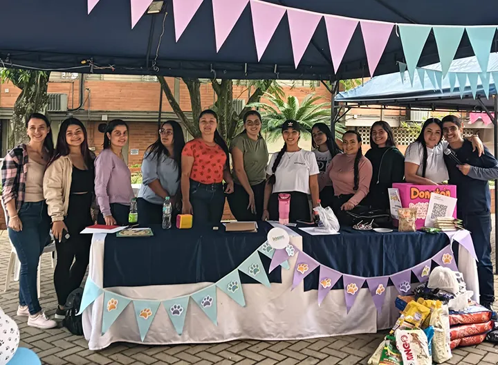 Estudiantes participando en el stand del proyecto social de formación en UNIMINUTO.