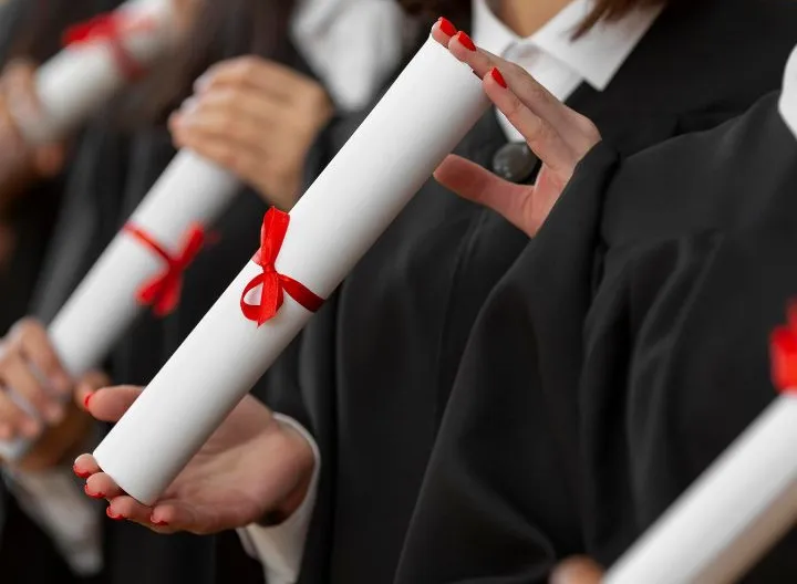 manos sosteniendo diplomas