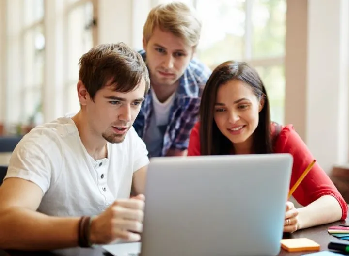 estudiantes observando pantalla de computador