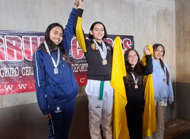 Estudiantes en podio posando con medalla de reconocimiento