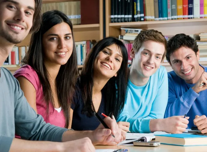 grupo de cinco estudiantes en salón de clases
