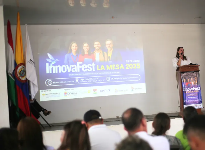 Coordinadora en tarima presentando programa