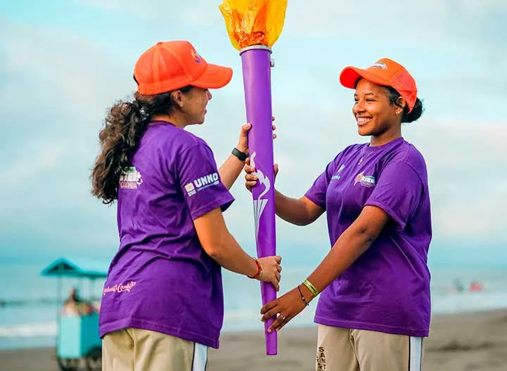Dos niñas participantes sostienen la antorcha de las olimpiadas STEM