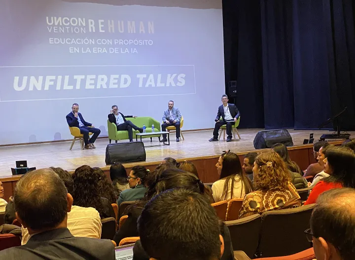 Cuatro ponentes en tarima dialogando frente al público asistente.
