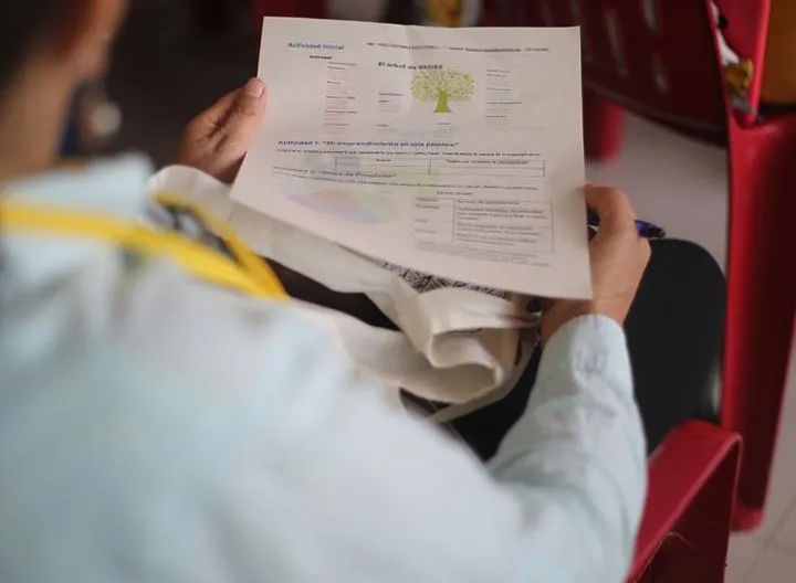 Hombre sentado sosteniendo una hoja en taller