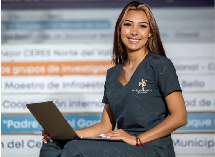 estudiante con uniforme de UNIMINUTO y un portátil