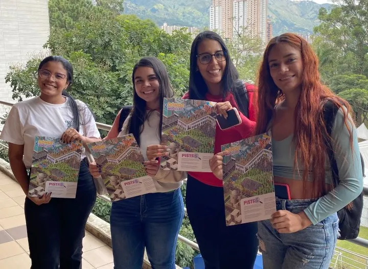 Estudiantes sonrientes mostrando mapa del concurso