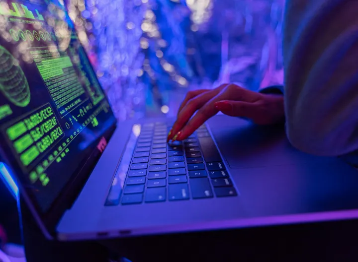 Persona trabajando en un computador visualizando fórmulas y código informático en pantalla, representando el desarrollo tecnológico, la programación y el uso de software libre promovido en el FLISoL 2026 de UNIMINUTO Tolima-Huila.