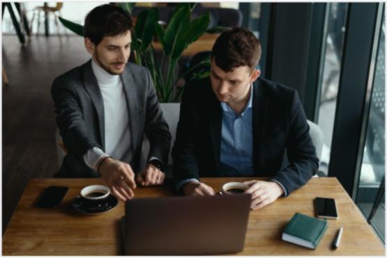 Dos personas trabajando frente a un computador portatil