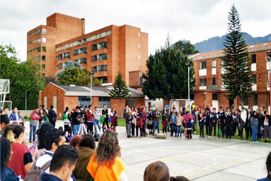 Un grupo de personas de diferentes étnias comparten de un encuentro en la cancha de fútbol del centro de operación San Camilo