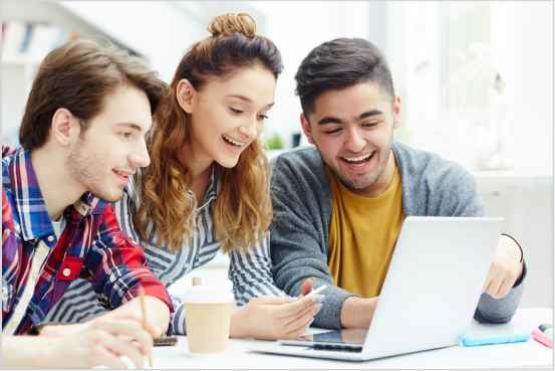 Dos estudiantes hombre y una mujer frente a computador portatil estudiando