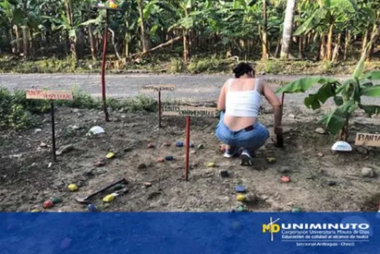 Estudiante mujer en cuclillas  en huerta rural. 
