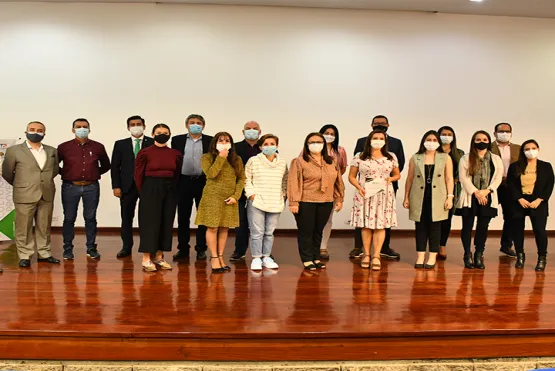 Rectores de las universidades de la red de pie, en dos filas en el escenario del teatro.