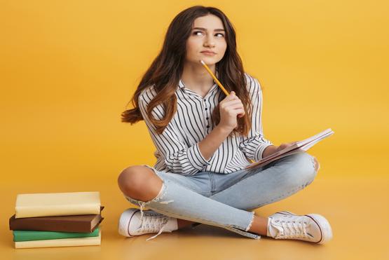 Chica con libros pensando qué escribir