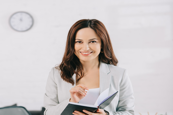 Mujer sonriente con libro en la mano