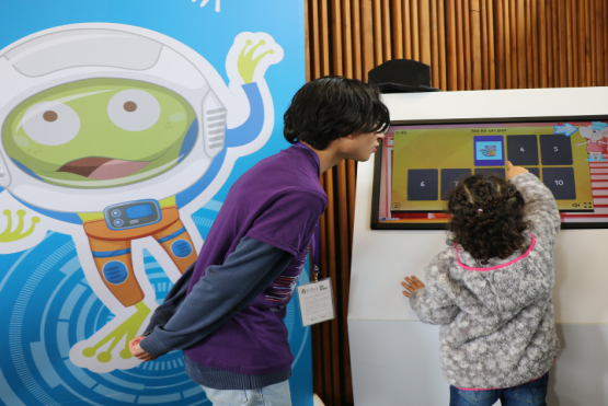 Estudiante UNIMINUTO guiando a niña participante de la FILBO