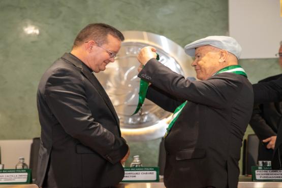 padre harold castilla recibiendo medalla